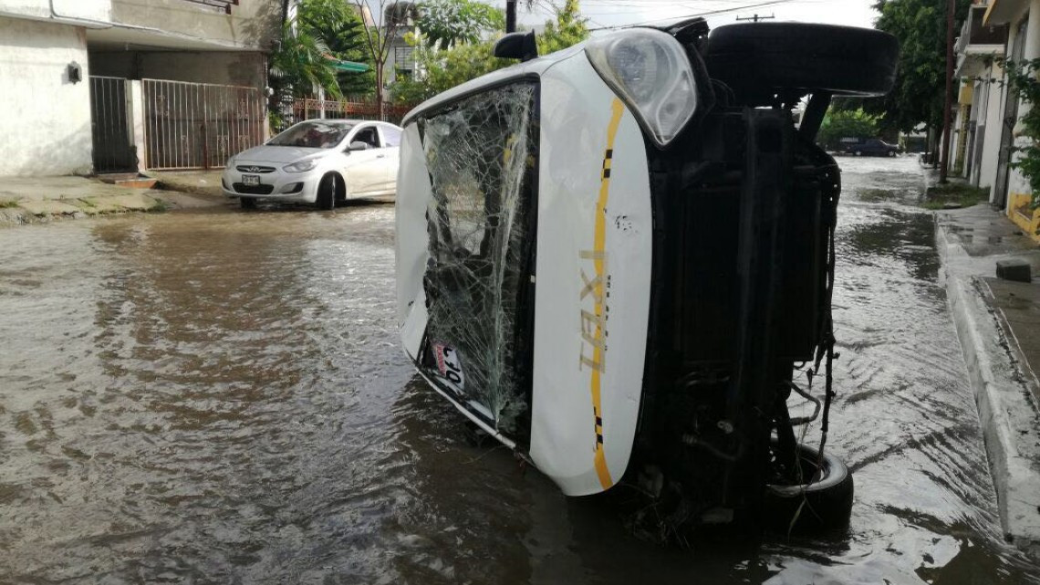 Corriente arrastra taxi en Madero