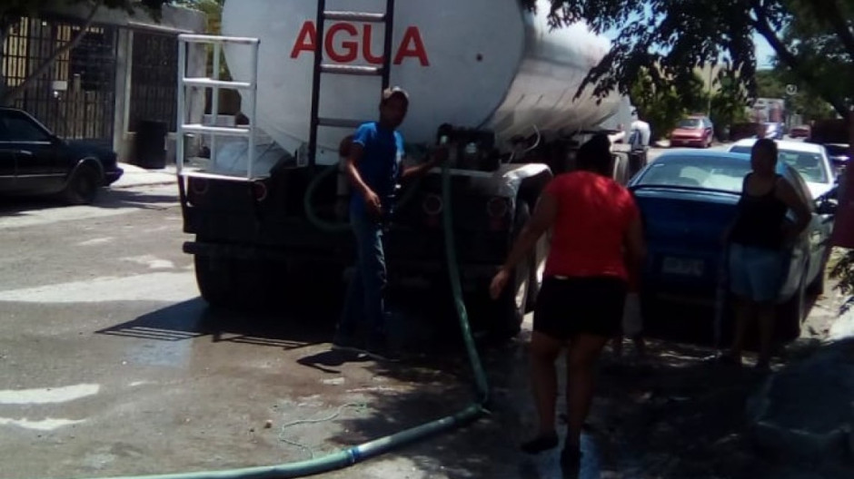 Vecinos ayudan a conductores de pipas en la entrega de agua potable