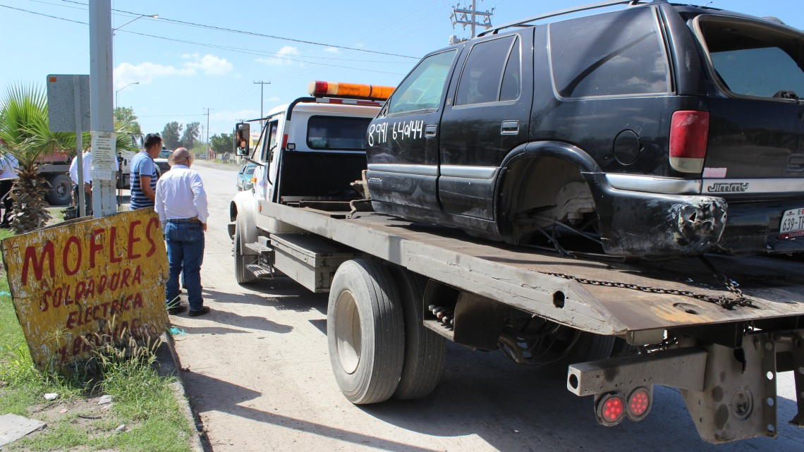 Retiran vehículos desmantelados por invadir vía pública