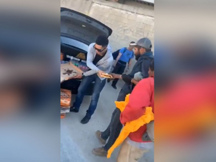 Joven reparte pizza a personas en situación de calle