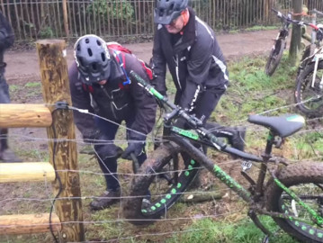  Tres hombres luchan por liberar una bicicleta de una cerca